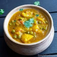 Bol d'Aloo Matar, un curry indien végétarien à base de pommes de terre, petits pois et sauce épicée, garni de coriandre fraîche.